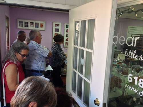 A small store has a line of customers around the shop and out the door. 