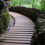 A boardwalk trail winds beside a rock face.
