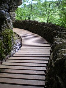 A boardwalk trail winds beside a rock face.