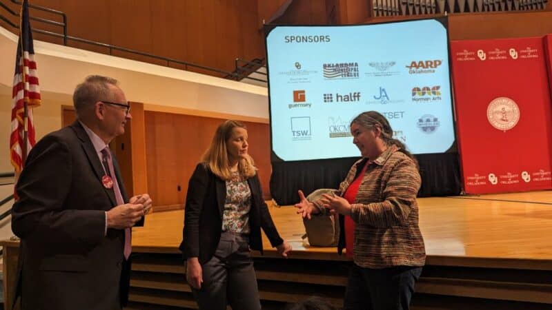Photo by Cheryl Lawson Three people standing in front of a stage having a conversation