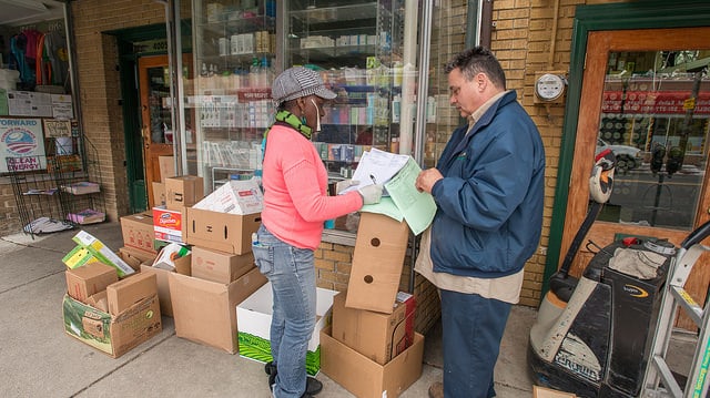 A retail store owner checks in an order from a supplier.