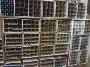 Book shelves with divided cardboard boxes filled with wine bottles