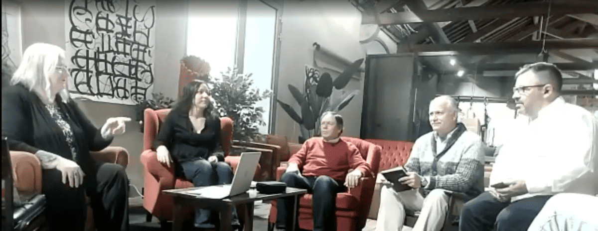 A panel of people seated in a coworking space holding a discussion.